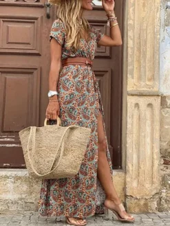 Une femme élégante porte une robe longue à motif paisley aux tons rouille