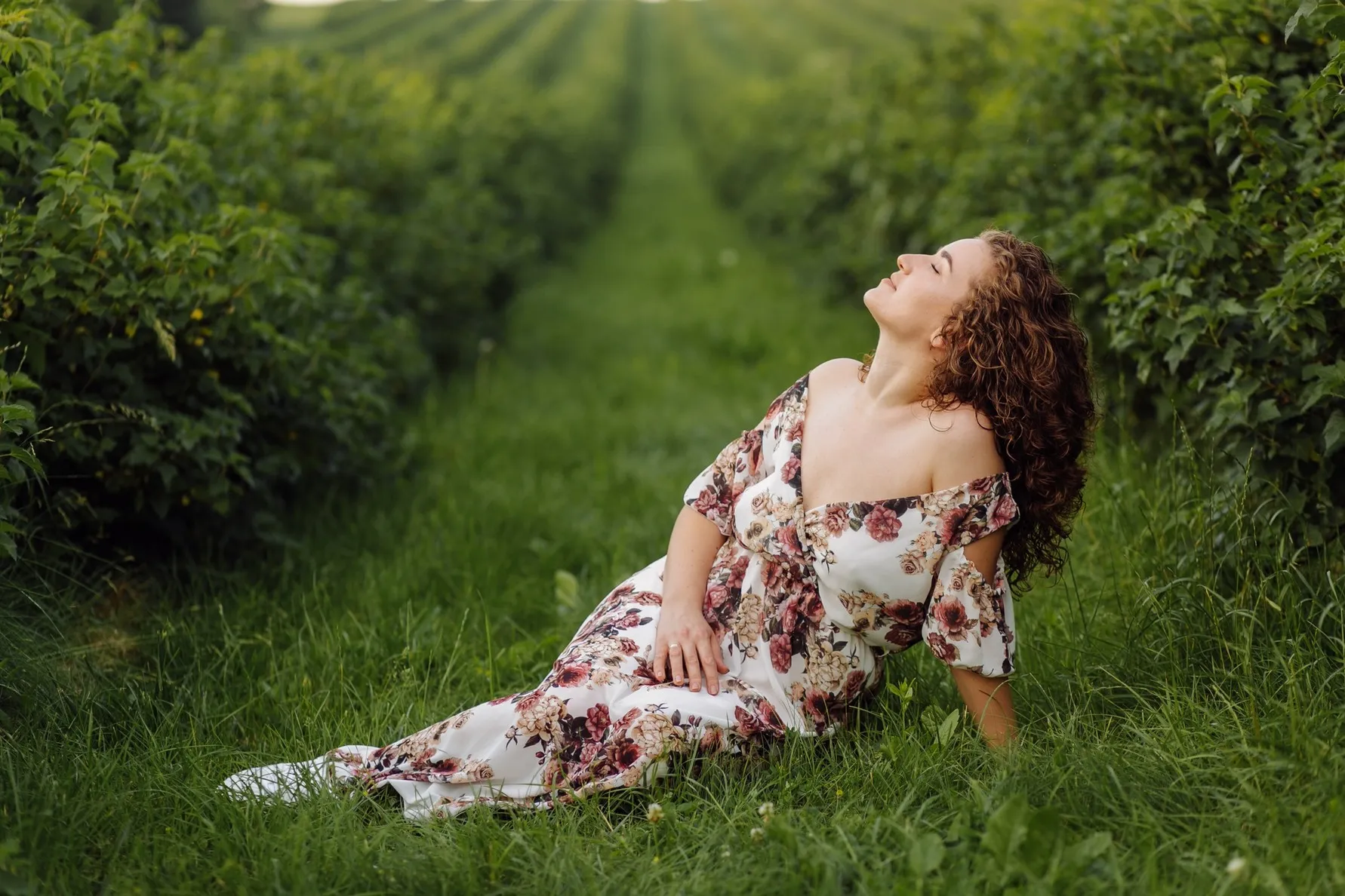 jeune-femme-heureuse-aux-cheveux-bruns-frisés-portant-une-robe-posant-un-jardin-en-extérieur jeune-femme-heureuse-aux-cheveux-bruns-frisés-portant-une-robe-posant-un-jardin-en-extérieur