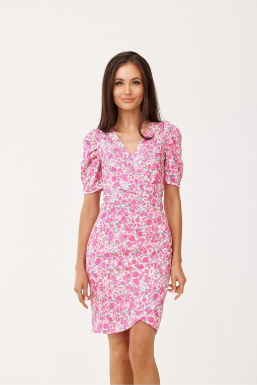 Femme brune portant la robe Gaïa à imprimé floral rose avec encolure cache-cœur et manches bouffantes